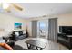 Living room with ceiling fan, TV and sliding glass doors opening to a balcony with ocean view at 13500 Gulf Blvd # 505, Madeira Beach, FL 33708