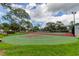 Community basketball court, with well-maintained green and red surfaces surrounded by lush grass and clear skies at 136 Sycamore Ln # C, Oldsmar, FL 34677