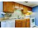 Well-lit kitchen with wood cabinets, tiled backsplash, and white range at 136 Sycamore Ln # C, Oldsmar, FL 34677