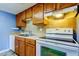 View of kitchen with wood cabinets, backsplash, range, and dishwasher at 136 Sycamore Ln # C, Oldsmar, FL 34677
