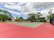 Well-maintained community tennis courts featuring vibrant red and green surfaces, perfect for recreational matches under a sunny sky at 136 Sycamore Ln # C, Oldsmar, FL 34677