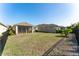 Expansive backyard features lush grass, a black fence, and the home's exterior at 13915 Kingfisher Glen Dr, Lithia, FL 33547