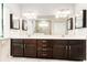 Double vanity with stone countertops, dark wood cabinets, decorative mirrors and recessed lighting at 13915 Kingfisher Glen Dr, Lithia, FL 33547