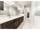 Bathroom featuring double sinks, dark wood cabinets, and a walk-in shower for a spa-like experience at 13915 Kingfisher Glen Dr, Lithia, FL 33547