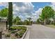 Well-manicured community entrance gate, featuring lush landscaping and a secure entry system at 13915 Kingfisher Glen Dr, Lithia, FL 33547