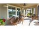 Relaxing screened-in lanai features wicker furniture and a ceiling fan, perfect for enjoying the outdoors at 13915 Kingfisher Glen Dr, Lithia, FL 33547