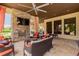 Elegant outdoor living space featuring a stone fireplace, ceiling fan and comfortable seating area at 13915 Kingfisher Glen Dr, Lithia, FL 33547