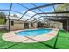 Enjoy outdoor living with a large screened pool, patio, and grassy yard, perfect for relaxation and entertainment at 15306 Winterwind Dr, Tampa, FL 33624