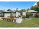 Charming single story home with lush front lawn and colorful flower pots at 15306 Winterwind Dr, Tampa, FL 33624
