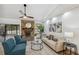 Bright living room with stone fireplace, modern ceiling fan, sofa, and chairs on wood-look flooring at 15306 Winterwind Dr, Tampa, FL 33624