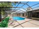 Backyard oasis boasts a screened-in pool with ample deck space for lounging, adjacent to a grassy area and privacy fence at 15306 Winterwind Dr, Tampa, FL 33624