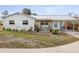 Charming single-story home with a metal roof and cozy front porch seating area at 15630 Camrose Ave, Spring Hill, FL 34610