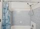 Tiled shower and tub combo with a shower curtain and updated shower head at 15630 Camrose Ave, Spring Hill, FL 34610