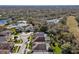 Aerial view of a neighborhood featuring houses with pools, lush greenery, and a scenic lake at 18908 Fairwood Ct, Tampa, FL 33647