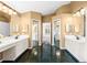 Dual sink bathroom with mirrors and dark tile flooring at 18908 Fairwood Ct, Tampa, FL 33647