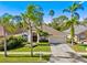 Charming single-Gathering home featuring a well-manicured lawn, mature palm trees, and a two-car garage at 18908 Fairwood Ct, Tampa, FL 33647