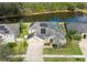 Stunning aerial view of the property, showcasing solar panels, screened pool, and serene lake at 20330 Natures Corner Dr, Tampa, FL 33647