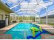 Beautiful pool with full screen enclosure, a spa, and spacious brick patio surrounded by lush greenery at 20330 Natures Corner Dr, Tampa, FL 33647