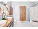 Well-lit bathroom featuring double sinks, wooden cabinets, and a bathtub with shower at 2352 Lake Woodberry Cir, Brandon, FL 33510
