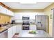 Functional kitchen with white cabinetry, stainless steel appliances, granite counters, and a central island offering plenty of workspace at 2352 Lake Woodberry Cir, Brandon, FL 33510