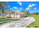 A view of the house showcasing the lawn, driveway, and architectural roof details at 2412 Gallagher Rd, Dover, FL 33527