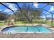 Screened-in pool area with a pool, lounge chairs, and ample space for entertaining at 2412 Gallagher Rd, Dover, FL 33527