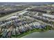 Aerial view of a residential neighborhood with houses with attached garages, lush greenery, and community lakes at 29011 Trevi Pl, Wesley Chapel, FL 33543