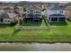 An aerial view showcasing a backyard with a fence, patio, and proximity to a serene lake at 29011 Trevi Pl, Wesley Chapel, FL 33543
