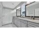 Bathroom featuring a double sink vanity with granite counters and a glass enclosed shower at 29011 Trevi Pl, Wesley Chapel, FL 33543