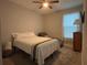 Bedroom with neutral walls, carpet flooring, a queen bed, and a sitting chair at 29011 Trevi Pl, Wesley Chapel, FL 33543