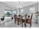 Bright dining room with stylish lighting, a wooden table, and sliding glass doors to the patio at 29011 Trevi Pl, Wesley Chapel, FL 33543