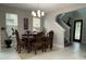 Dining room with dark wood table, seating for six, and modern chandelier lighting at 29011 Trevi Pl, Wesley Chapel, FL 33543