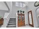 Bright foyer featuring staircase, front door, and elegant decor at 29011 Trevi Pl, Wesley Chapel, FL 33543