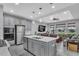 Modern kitchen features gray cabinetry, stainless steel appliances, and an island with seating at 29011 Trevi Pl, Wesley Chapel, FL 33543
