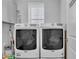 Convenient laundry room featuring a washer and dryer with overhead storage cabinets at 29011 Trevi Pl, Wesley Chapel, FL 33543