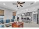 Open concept living room and kitchen with tile flooring, ceiling fan, and lots of natural light at 29011 Trevi Pl, Wesley Chapel, FL 33543