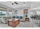 Bright living room featuring modern ceiling fan, neutral sectional, and beautiful wood floors at 29011 Trevi Pl, Wesley Chapel, FL 33543