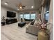Bright living room features a tray ceiling, tile floors, entertainment center, and plush furniture at 29011 Trevi Pl, Wesley Chapel, FL 33543