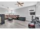Spacious living room with leather sectional sofa, ottoman, and television; also equipped with home gym at 29011 Trevi Pl, Wesley Chapel, FL 33543