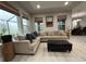 Comfortable living room featuring a sectional sofa, ottoman, tile flooring and natural light at 29011 Trevi Pl, Wesley Chapel, FL 33543