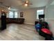 Large living room featuring a sectional couch, laminate flooring, exercise equipment, and natural light at 29011 Trevi Pl, Wesley Chapel, FL 33543