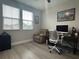 Cozy home office featuring two sunny windows, a comfortable chair, and desk set up with computer at 29011 Trevi Pl, Wesley Chapel, FL 33543