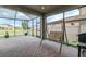 The covered lanai features brick pavers, a swing, and a backyard view at 29011 Trevi Pl, Wesley Chapel, FL 33543