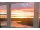 Stunning sunrise view from the windows overlooking a tranquil lake and the adjacent buildings at 29011 Trevi Pl, Wesley Chapel, FL 33543