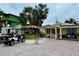 Charming yellow house with tropical landscaping, custom tiki bar, and a golf cart in the driveway at 3019 Dupont S St, Gulfport, FL 33707