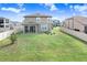 Large backyard featuring lush green grass, a covered patio, and white vinyl privacy fencing at 3027 Marine Grass Dr, Wimauma, FL 33598