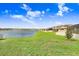 Beautiful backyard with a lush green lawn that leads to a serene lake view at 3027 Marine Grass Dr, Wimauma, FL 33598