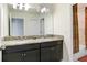 Bathroom with a double sink vanity, granite countertop, and walk-in shower at 3027 Marine Grass Dr, Wimauma, FL 33598