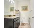 Elegant bathroom with granite countertop, dark cabinets and wood-look flooring at 3027 Marine Grass Dr, Wimauma, FL 33598