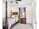 Cozy bedroom features a dark wood poster bed, plush carpet and a sunny window at 3027 Marine Grass Dr, Wimauma, FL 33598